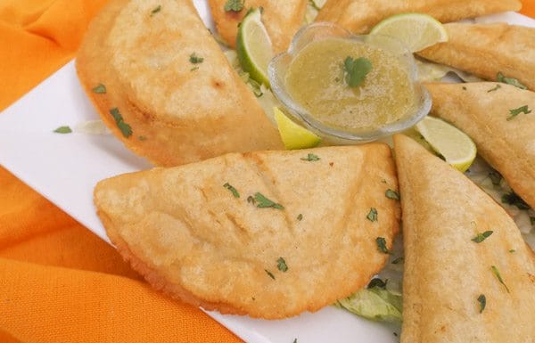 Mexican Empanadas with Green Sauce served on a white platter.