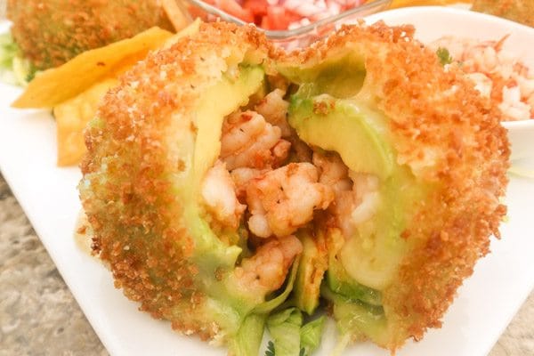 Fried Avocado Stuffed with Shrimp served on a white platter.