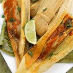 Mexican Tamales served on top of plantain leaves on a white plate.