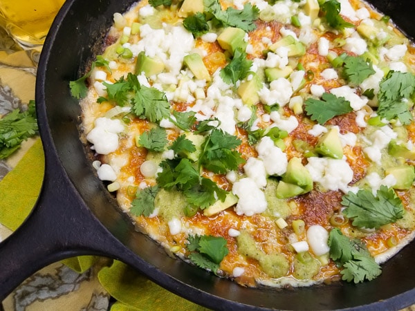 The Best Roasted Poblano Bean Dip is made with roasted poblano peppers, onions, scallions, garlic, cilantro, refried beans, shredded pepper jack cheese, topped with a poblano sauce and finished with queso fresco, scallions, avocado cubes and more cilantro. All served in a cast iron skillet. Excellent dip!!