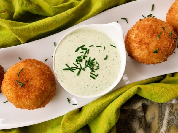 Rellenos de Papa (Stuffed Potato Balls), are stuffed with a savory picadillo or beef ground meat and fried leaving a crusty balance and perfectly moist on the inside served with a poblano dipping sauce.