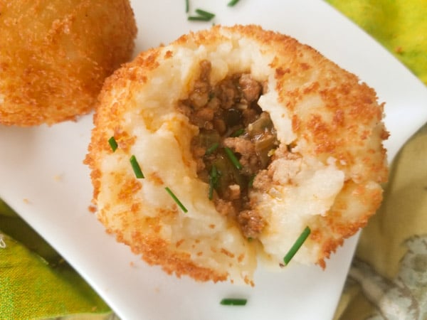 Rellenos de Papa (Stuffed Potato Balls), are stuffed with a savory picadillo or beef ground meat and fried leaving a crusty balance and perfectly moist on the inside served with a poblano dipping sauce.