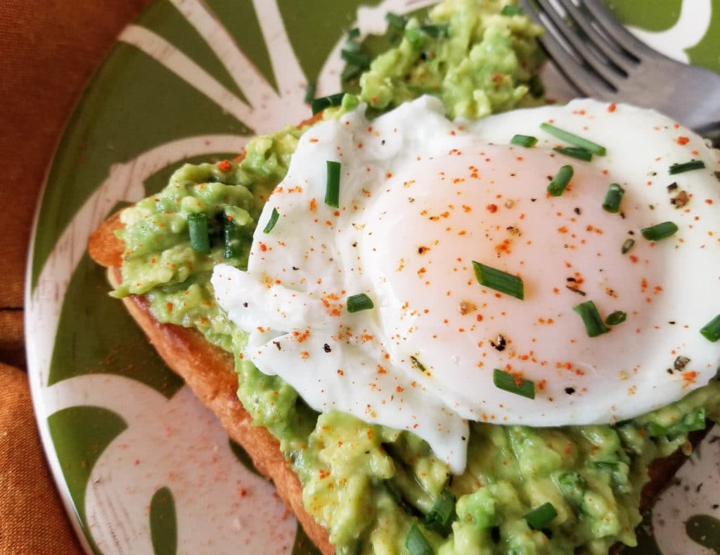 This simple poached egg and avocado toast is made with avocado spread that includes chives and cayenne pepper with a poached egg on toast. | mexicanappetizersandmore.com