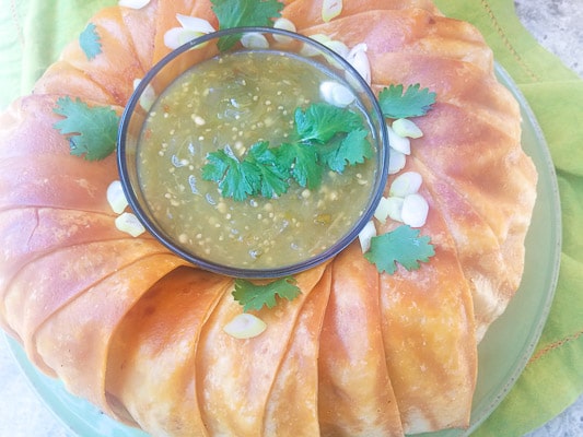 Taco Ring served with salsa verde on a green platter.