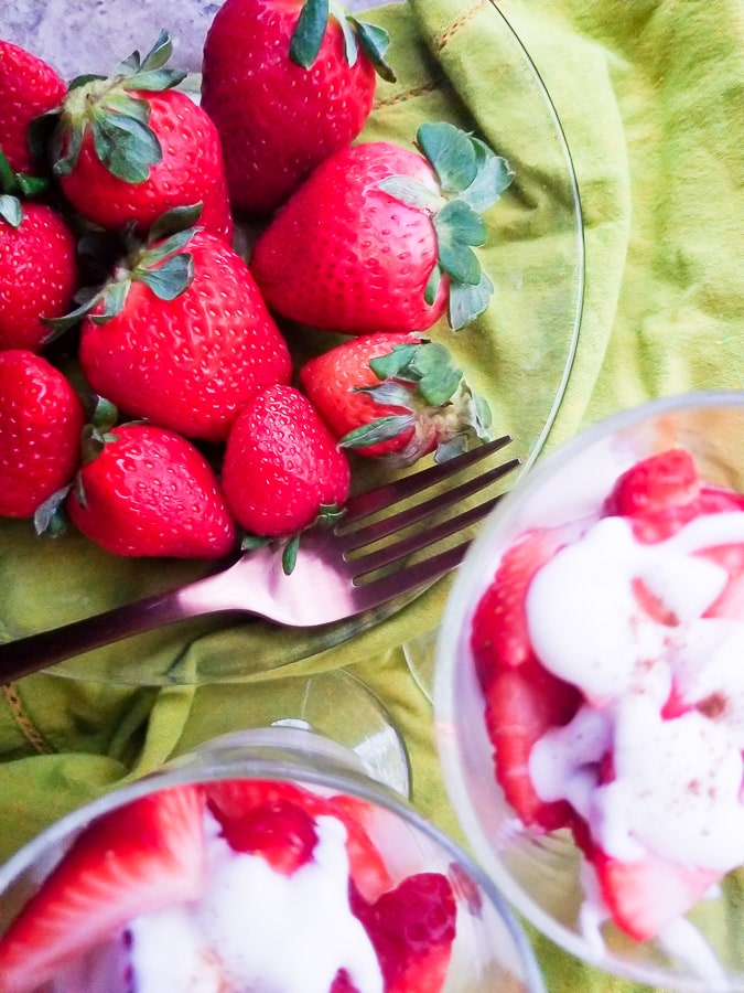 Fresas con Crema (Strawberries with Cream) served in small transparent glasses.