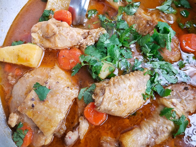 Pollo Guisado (Puerto Rico Chicken Stew) cooking in a caldero or dutch oven.