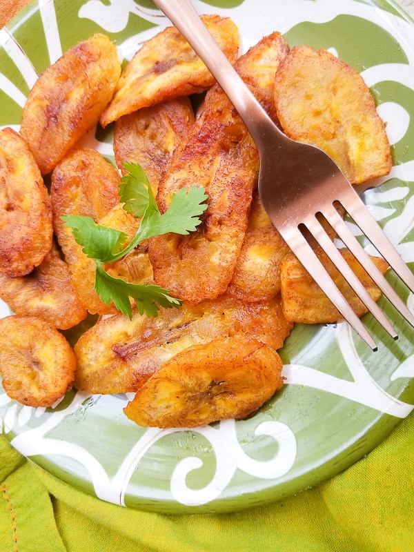 Platanos Fritos (Puerto Rican Sweet Plantains) on a green and white plate.