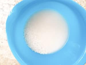 Rinsing white rice with water until clear.