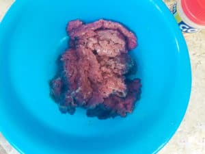 Cube steak seasoned with adobo in a blue bowl.