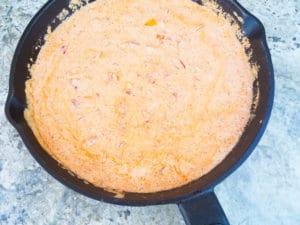 Creamy chipotle sauce cooking in a cast iron skillet for camarones a la crema.