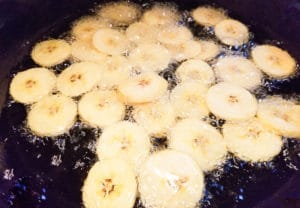 Plantain chips cooking in oil.