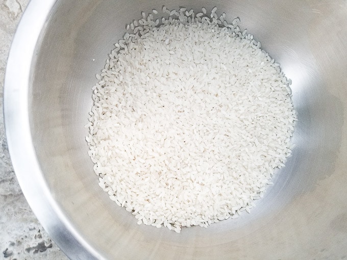 Dry medium grain rice in bowl ready to rinse.