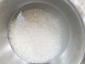 Medium grain rice after rinsing, water is clear now.