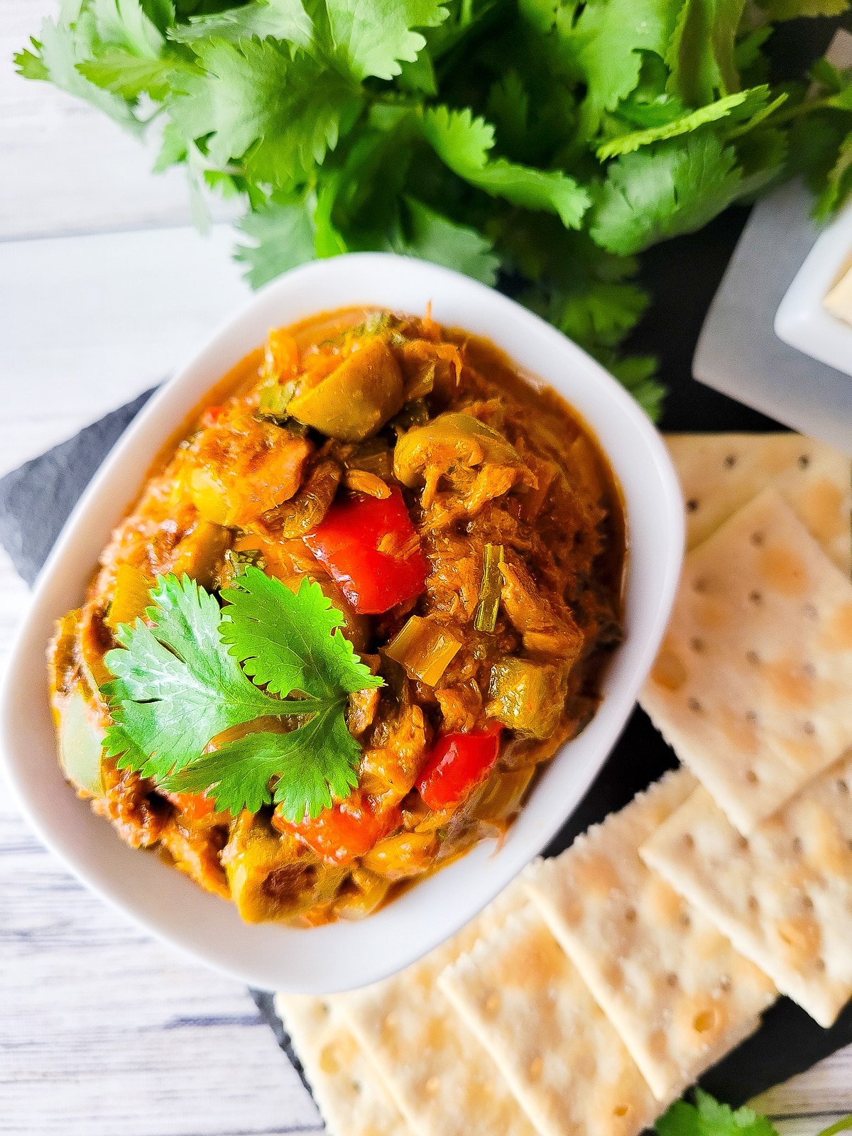 Antipasto de atun served in a small dip bowl with a side of saltine crackers.