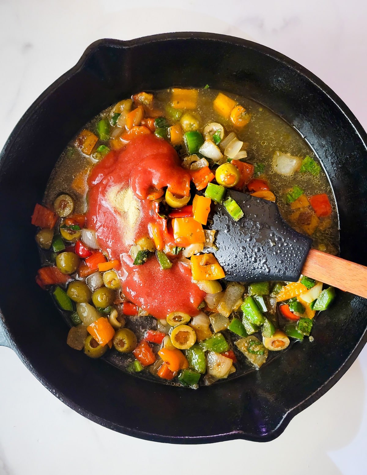 Tomato sauce, chicken broth and adobo added to the skillet.