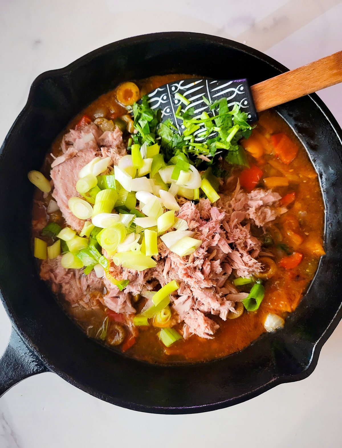 The canned tuna and scallions added into the skillet.