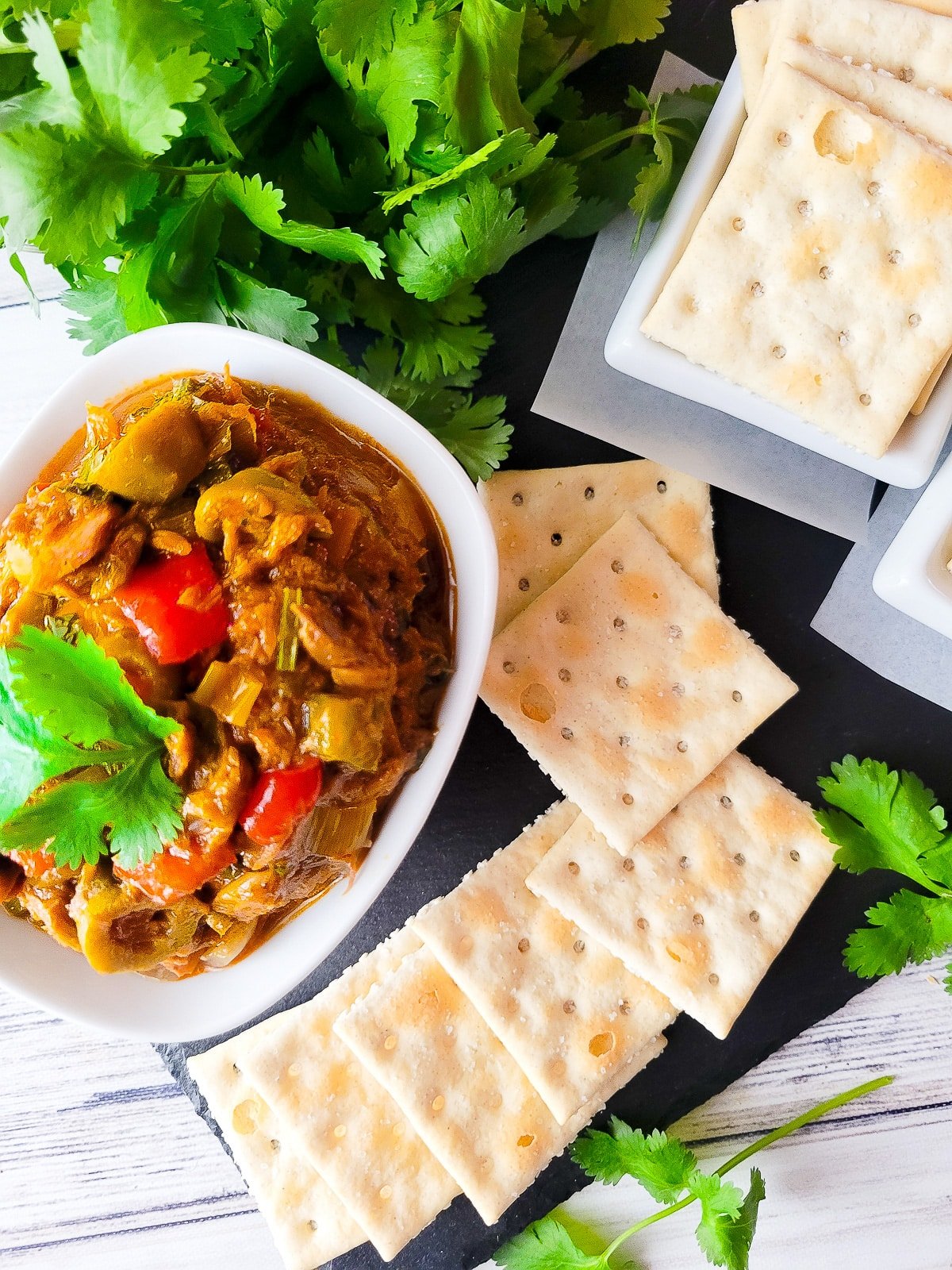 Antipasto de atun served in a small dip bowl with a side of saltine crackers.