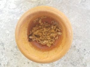 Garlic and spices mashed in a mortar and pestle.