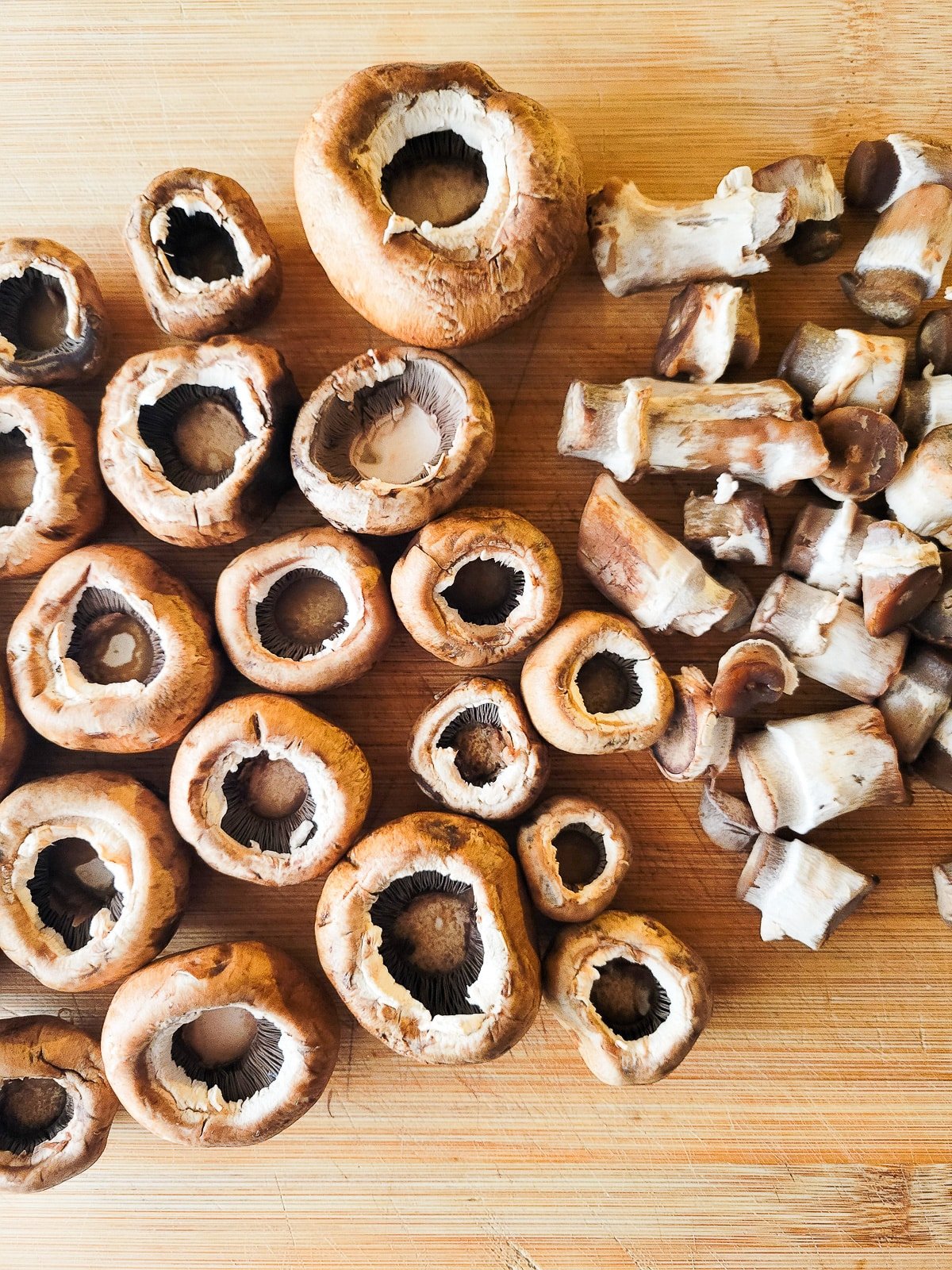 Cleaned mushrooms on a wooden cutting board.