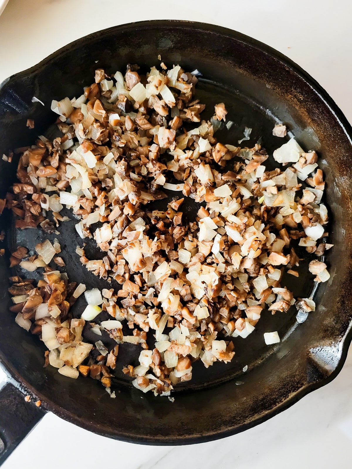 Sauteing the mushroom and onions in a cast iron skillet.