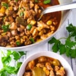 The carne para pasteles (pork filling) cooked in a caldero and a side serving in a white bowl.