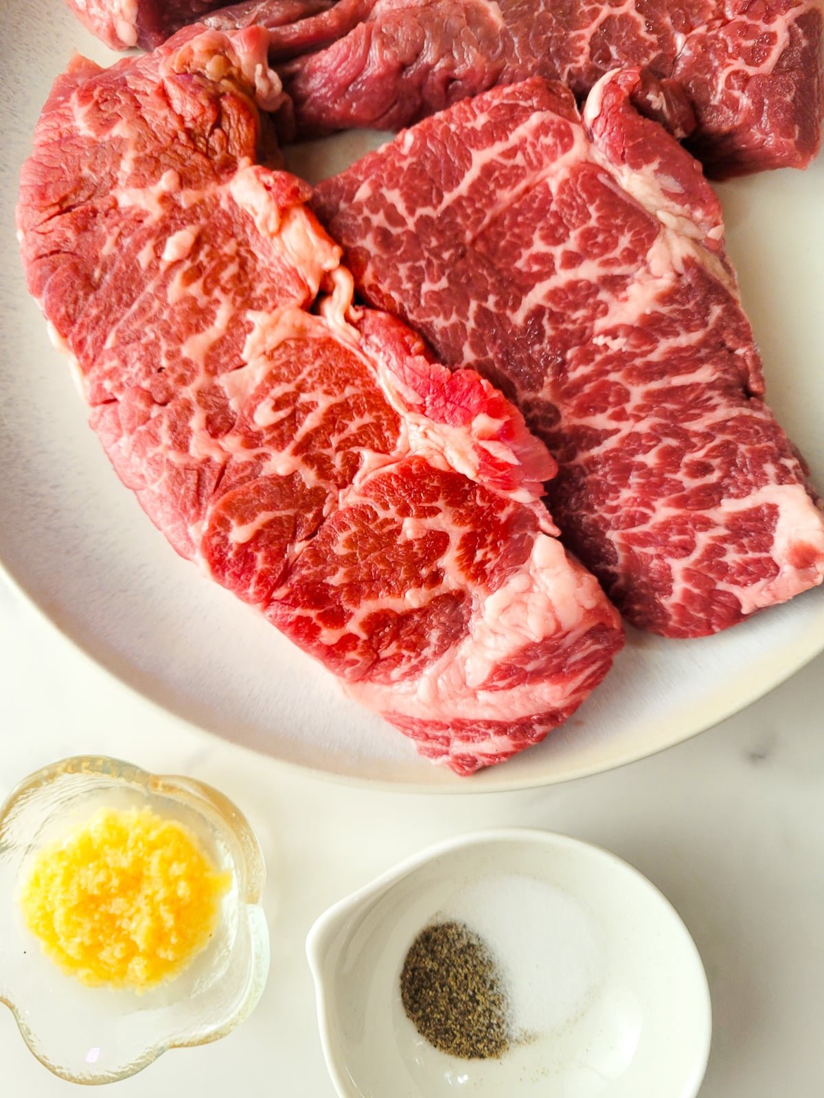 Photo of ingrediens for Denver steak. Garlic puree, salt and pepper.