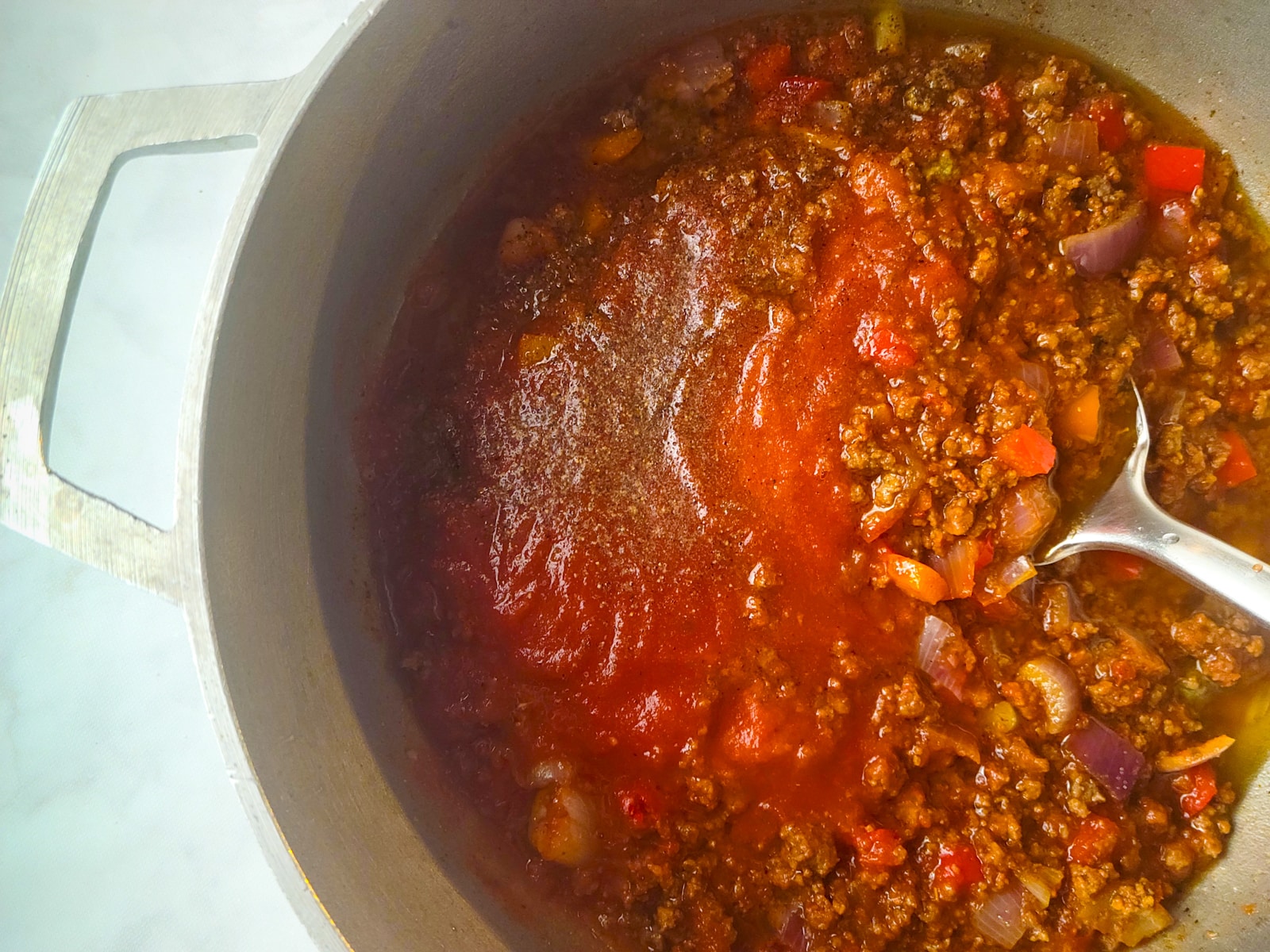 The tomato sauce added to the pot.