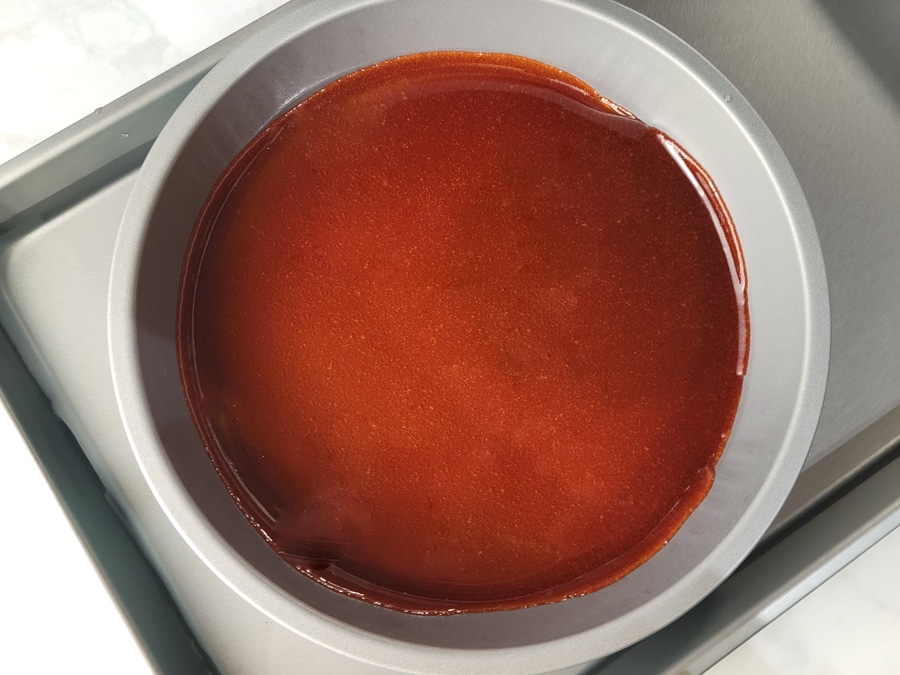 Caramel sauce spread on the bottom of the flan mold and placed inside another mold for the water bath(baño de Maria).