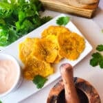 Puerto Rican garlic tostones served on a white platter with a side of mayoketchup.