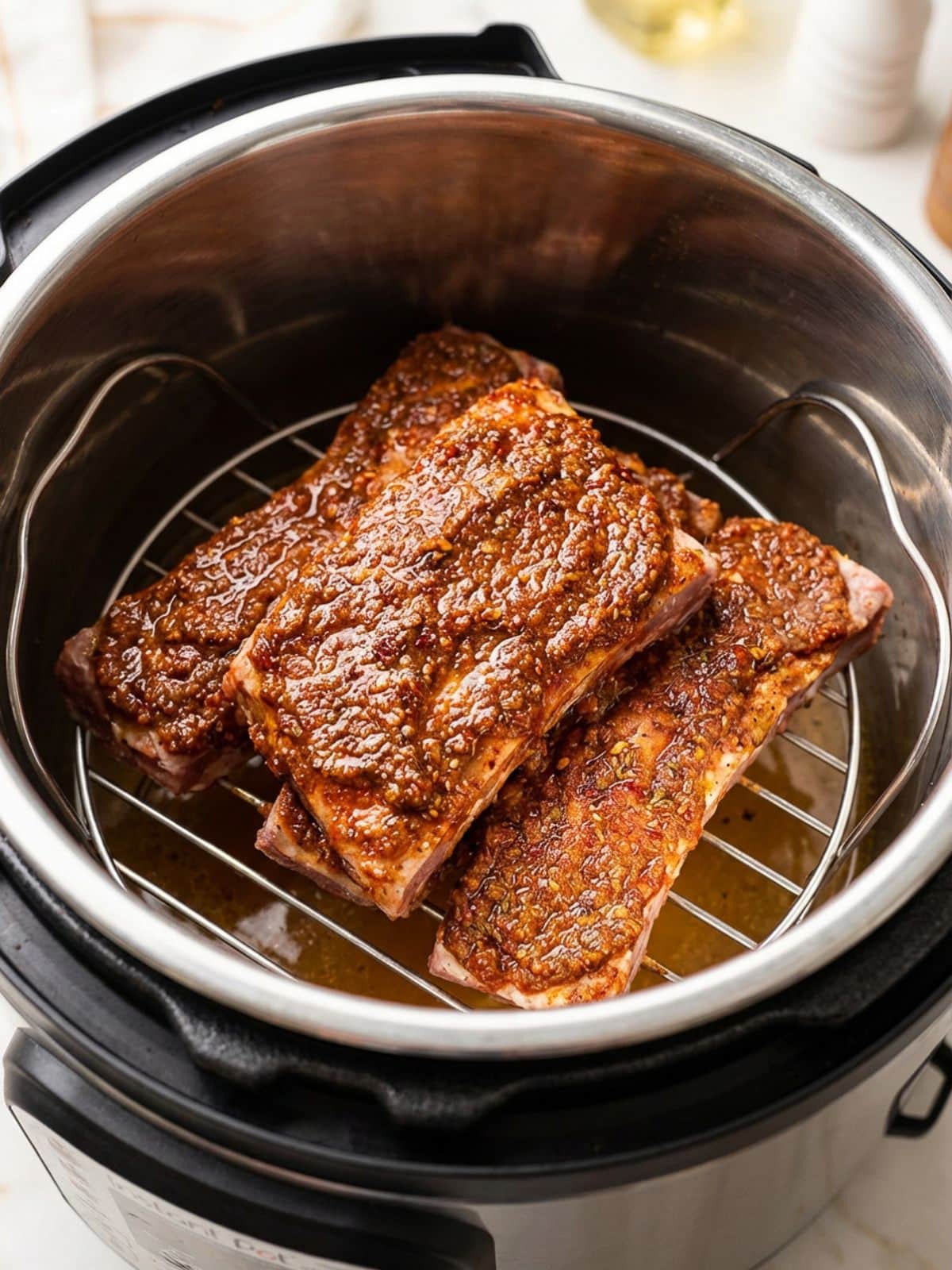 The seasoned boneless pork ribs sitting inside the Instant Pot rack insert.
