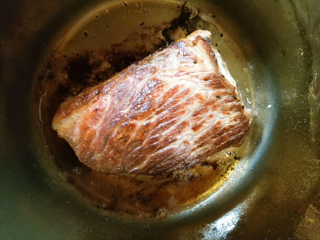 Seared and brown beef round roast inside an instant pot.