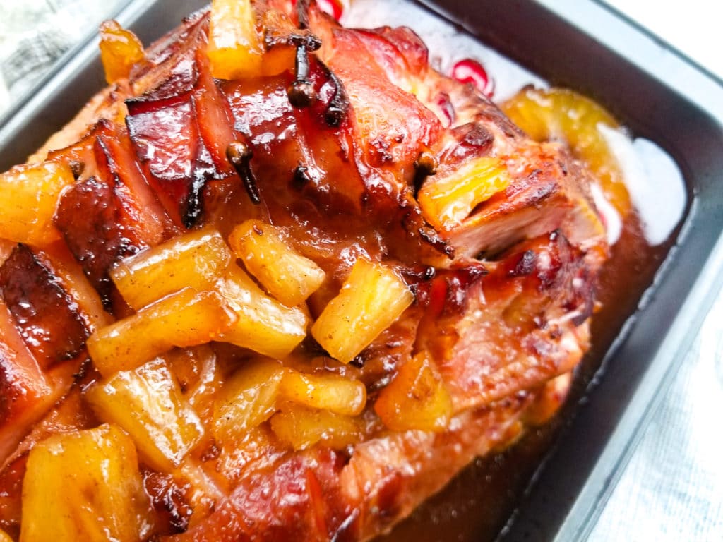 Jamon al Horno con Pina (Baked Ham with Pineapple Glaze) fully cooked in a baking tray and topped with pineapple glaze and pineapple chunks.