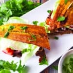 Jibarito Sandwich (Sandwich de Toston) served on a white platter with a side of cilantro garlic aioli.