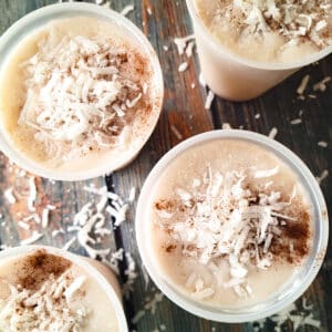 Limber de Coco (Coconut Limber) prepared and frozen in plastic cups, topped with shredded coconut and ground cinnamon.