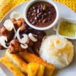 Masitas de puerco served on a plate with a side of white rice and fried yuca.