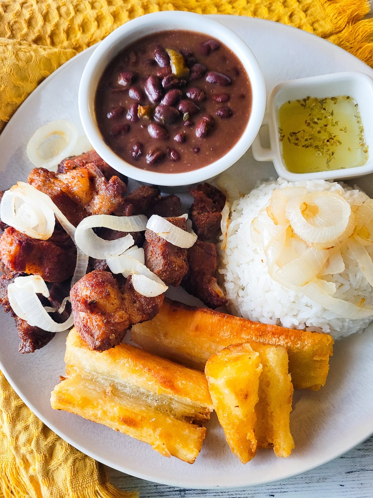 Masitas de puerco served on a plate with a side of white rice and fried yuca.