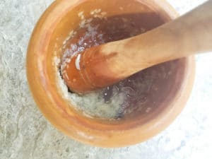 Garlic paste formed in a mortar and pestle.