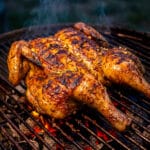 Pollo Asado al Carbon cooking over an open fire pit of lump charcoal.