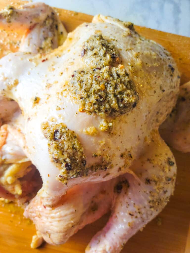 Adding more garlic oregano marinade to the chicken.