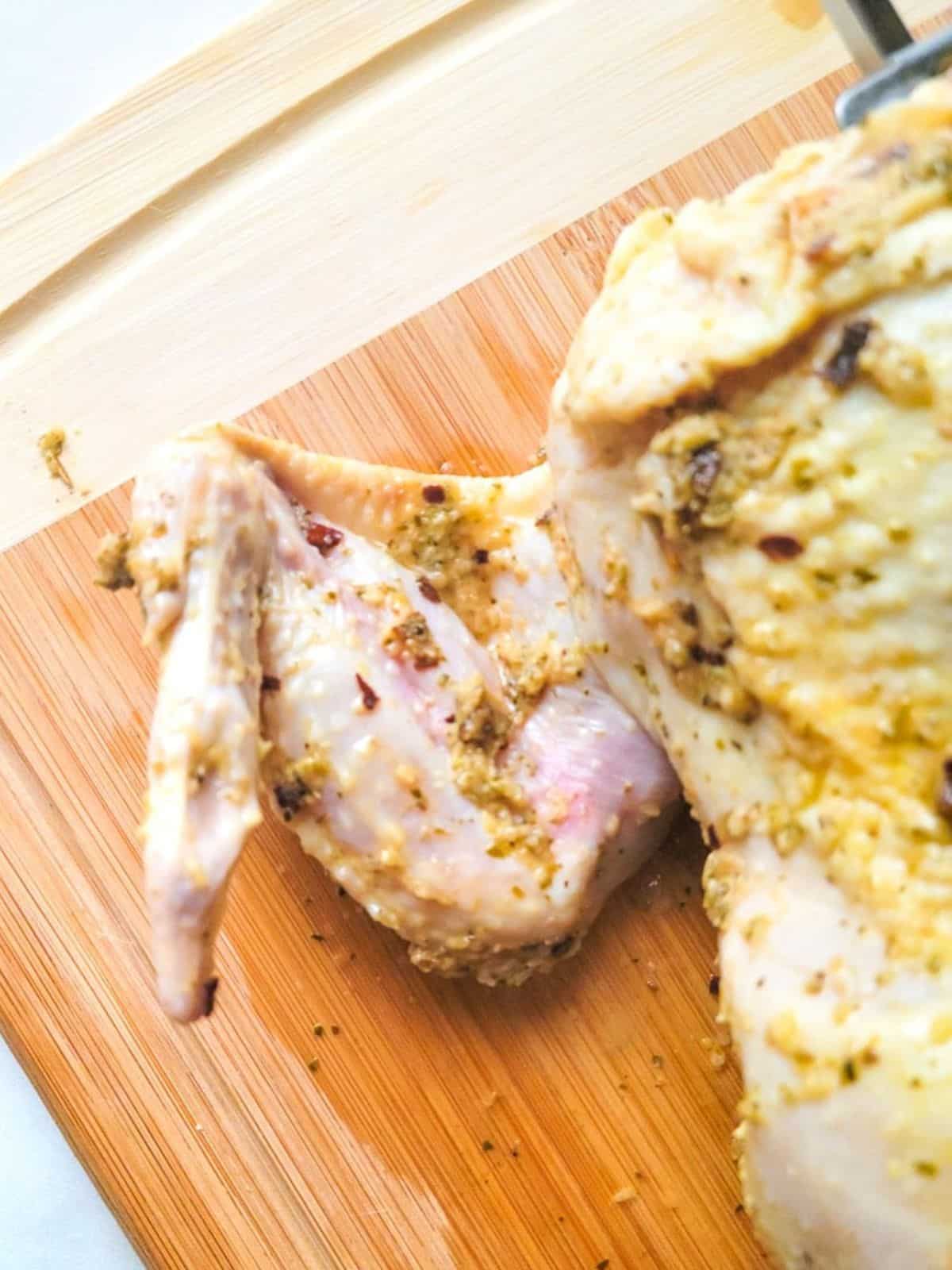 Trussing the chicken wings to cook the rotisserie chicken.