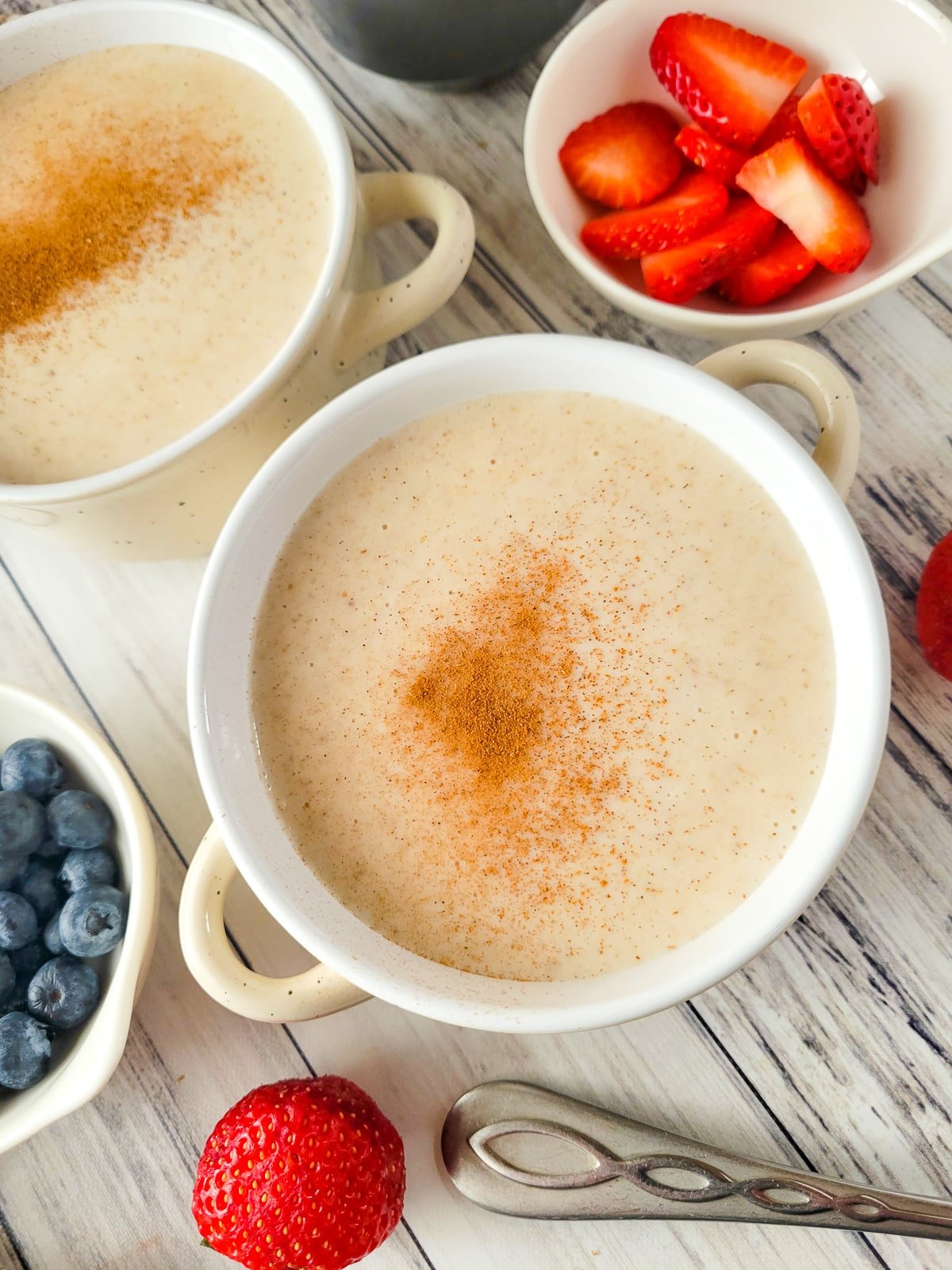 Two bowls of Puerto Rican oatmeal topped with ground cinnamon.