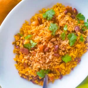 Puerto Rican Rice and Beans (Arroz con Habichuelas) served in a white platter and topped with chopped cilantro.
