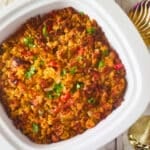 Relleno de Mofongo (Mofongo Stuffing) served in a white casserole with Christmas decor beside it.