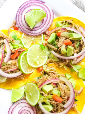 Salpicon de Res (Beef Salpicon) served on tostadas with lime wedges on a white platter.