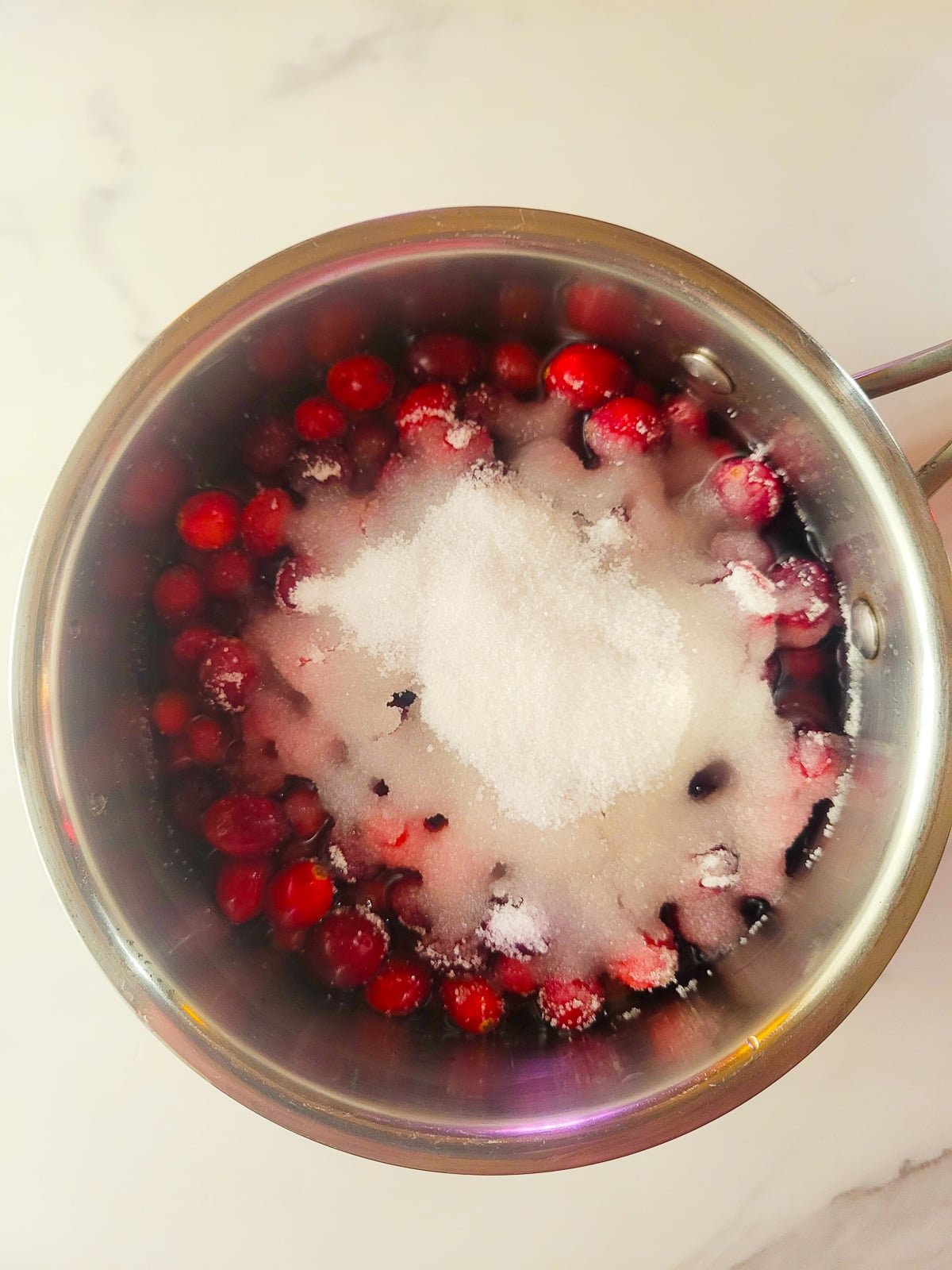 Cranberries, sugar and water in a saucepan for cranberry sauce.