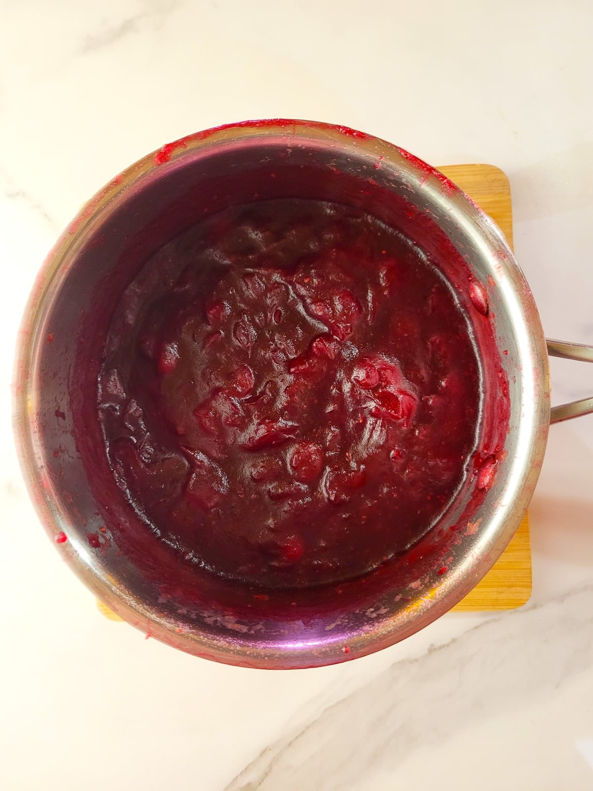 The salsa de arandanos fully cooked in the saucepan.