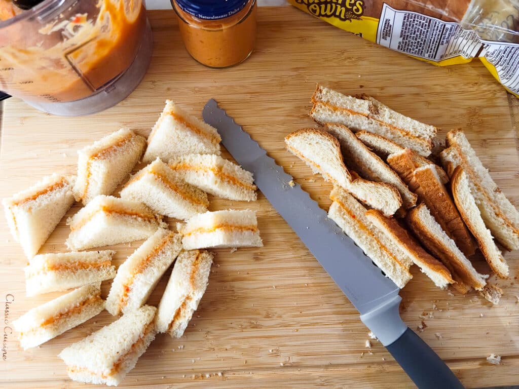 Cutting the crusts of bread and then  cutting them into quarters. 
