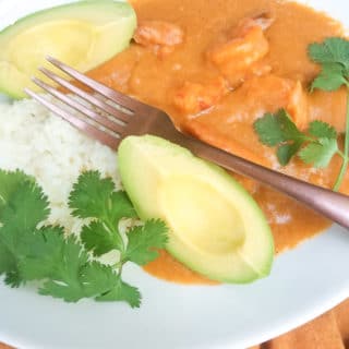 Sango de Camaron served with white rice and avocado slices, served in a white plate.