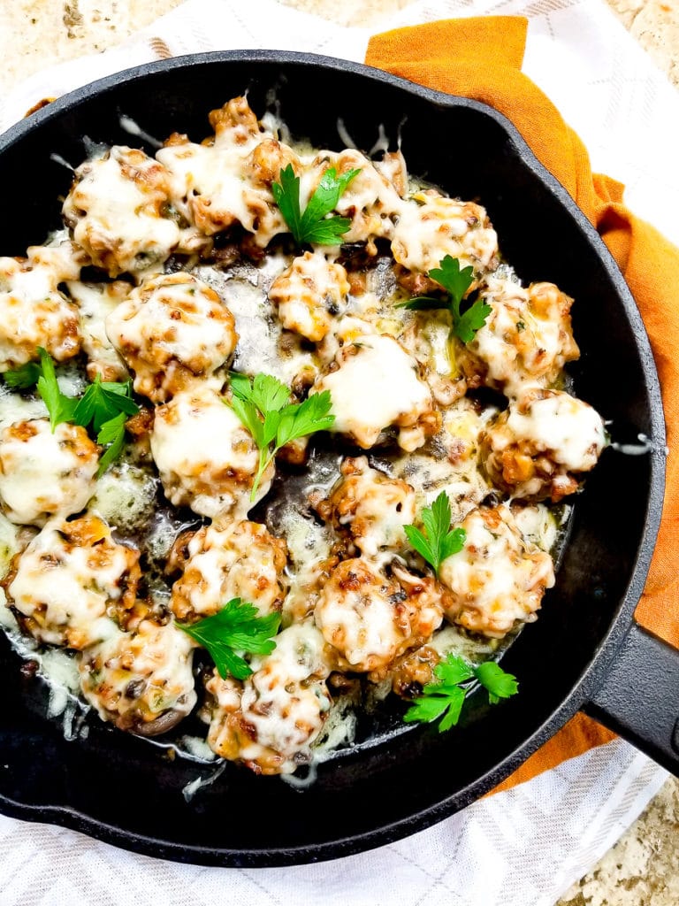 Skillet Stuffed Mushrooms (Hongos Rellenos) cooked in a cast iron skillet, topped with parsley sprigs.