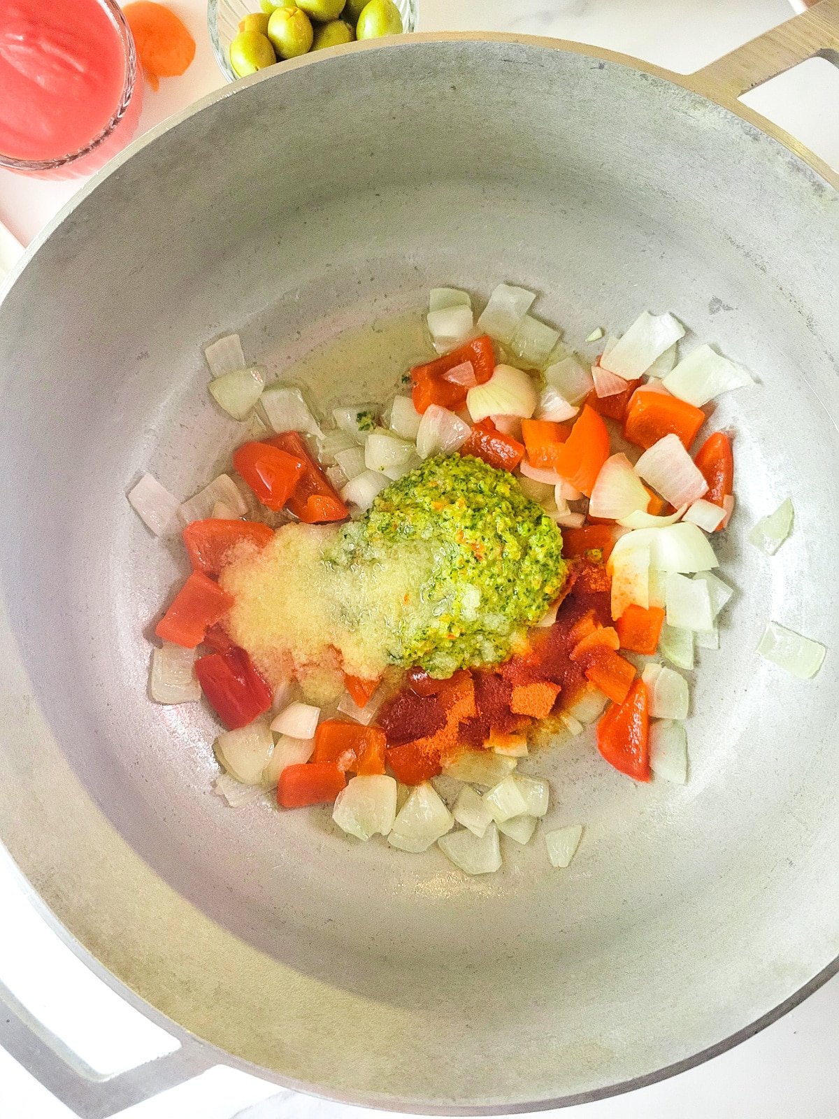 Peppers, onions, sofrito, sazon and garlic puree sautéing in a caldero.